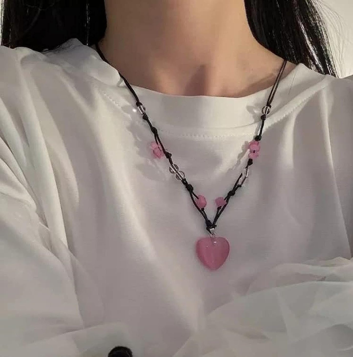 Heart-shaped pendant necklace featuring pink and black crystal angel wings.